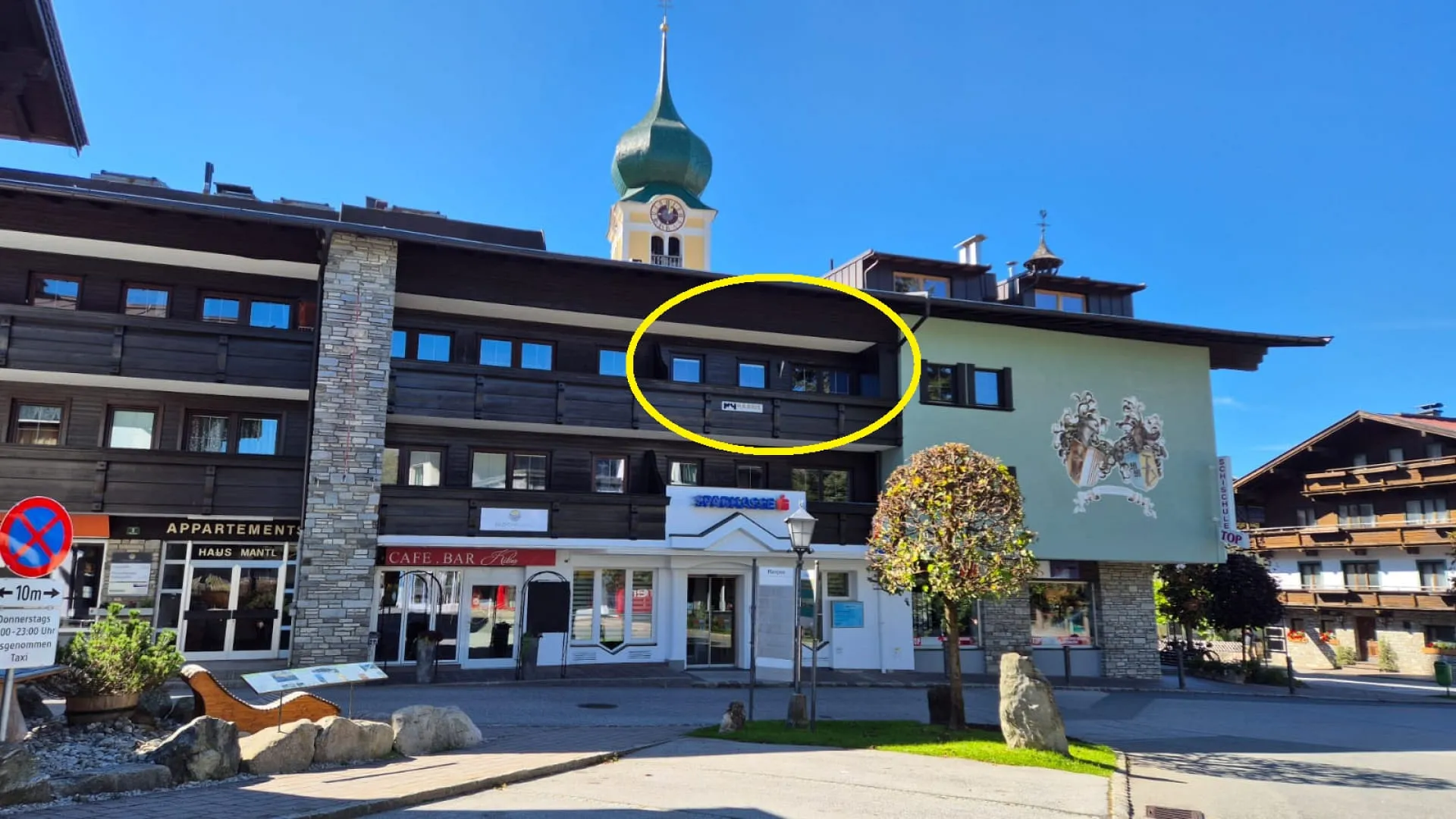 Uitzicht op Appartement Harrie Lage met een opvallende kloktoren op de achtergrond.